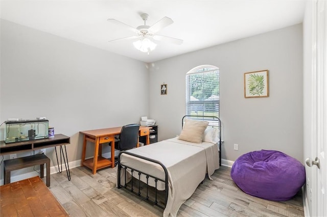 bedroom with baseboards, ceiling fan, and light wood finished floors