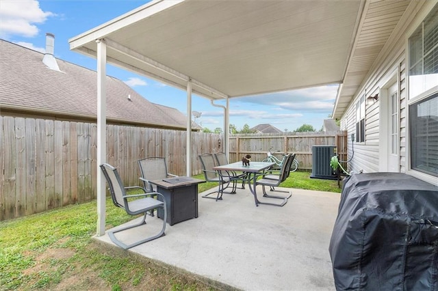 view of patio / terrace featuring cooling unit, outdoor dining area, a fenced backyard, a grill, and an outdoor fire pit