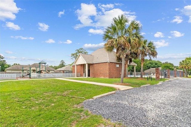 exterior space featuring a yard, brick siding, fence, and a playground