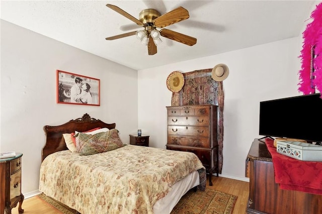 bedroom featuring baseboards, ceiling fan, and wood finished floors
