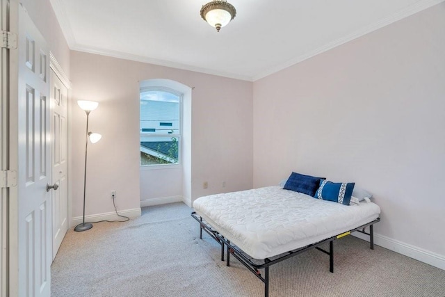 carpeted bedroom with crown molding and baseboards