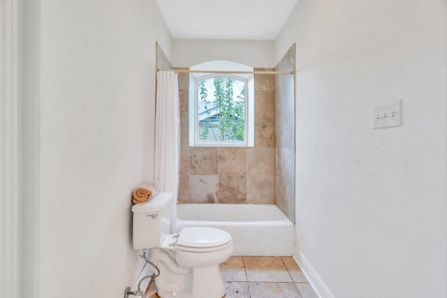 full bath with toilet, baseboards, and shower / bath combo