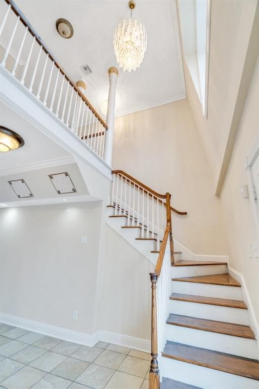 staircase featuring visible vents, a towering ceiling, tile patterned floors, baseboards, and a chandelier