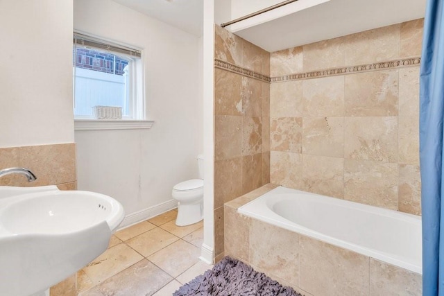 full bathroom with a sink, tile patterned floors, tiled shower / bath combo, and toilet