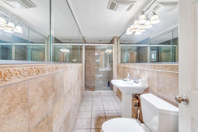 bathroom with visible vents, a stall shower, toilet, and tile walls