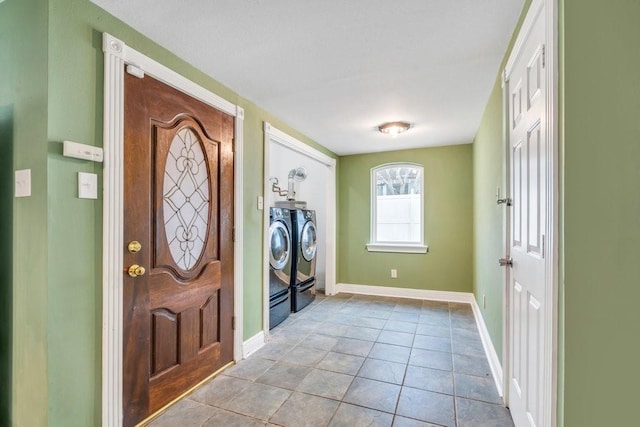 foyer with baseboards, washer and clothes dryer, and tile patterned flooring