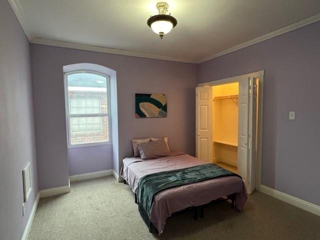 bedroom with crown molding, baseboards, a spacious closet, and light carpet