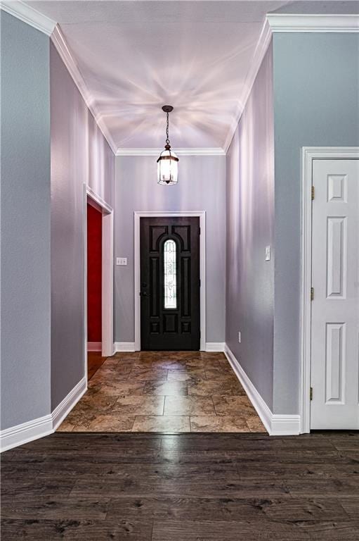 foyer entrance with crown molding, baseboards, and wood finished floors