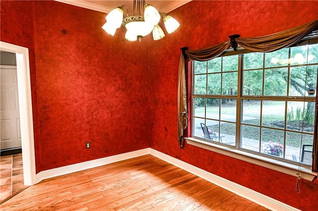 unfurnished room featuring baseboards, a chandelier, ornamental molding, and light wood-style flooring