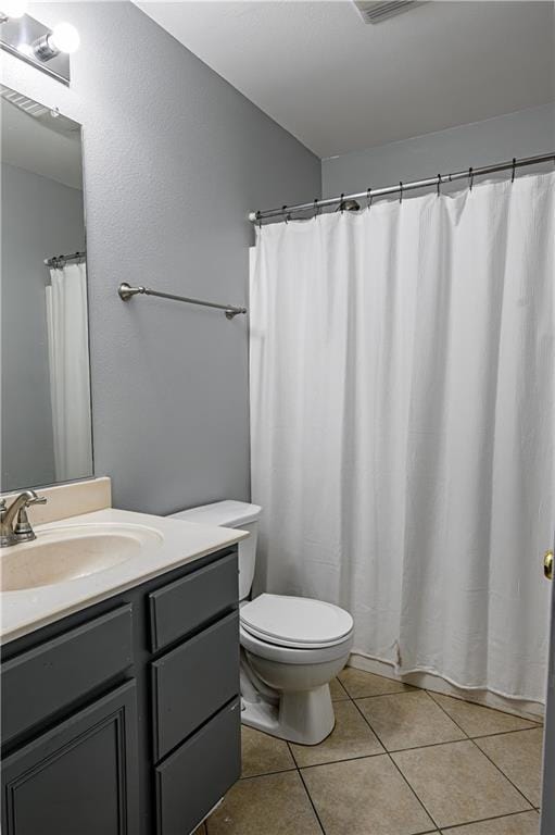 full bathroom with toilet, tile patterned floors, and vanity