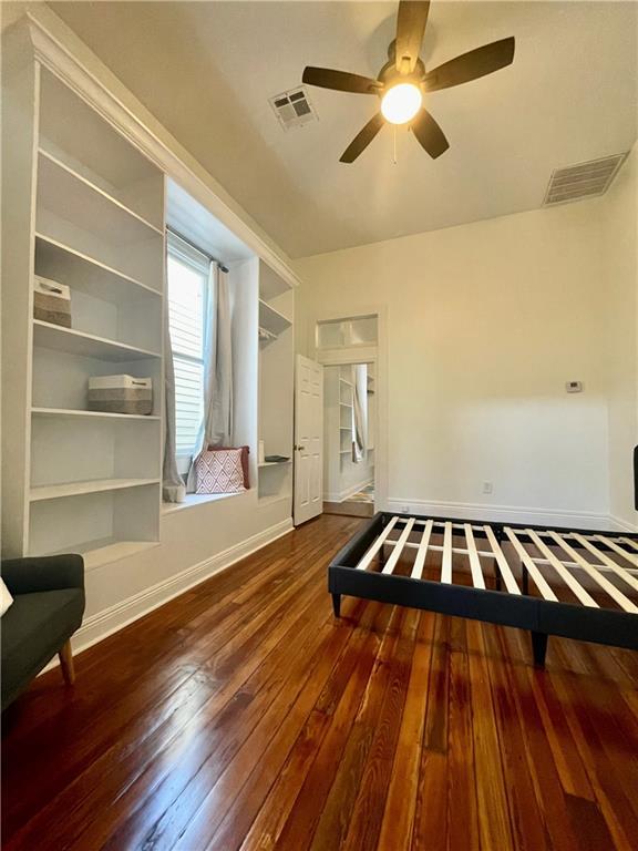 242325 Freret St, New Orleans, LA 70113 - unfurnished bedroom with visible vents, wood-type flooring, ceiling fan, and baseboards