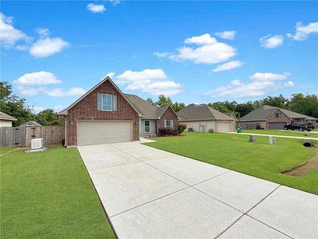 42273 Atmore Pl, Ponchatoula, LA 70454 - view of front of home with fence, a front yard, driveway, and brick siding