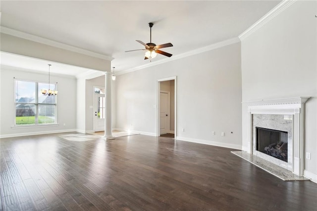 unfurnished living room with dark wood-style flooring, a premium fireplace, crown molding, and ceiling fan with notable chandelier