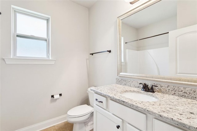 bathroom with vanity, baseboards, toilet, and tile patterned flooring