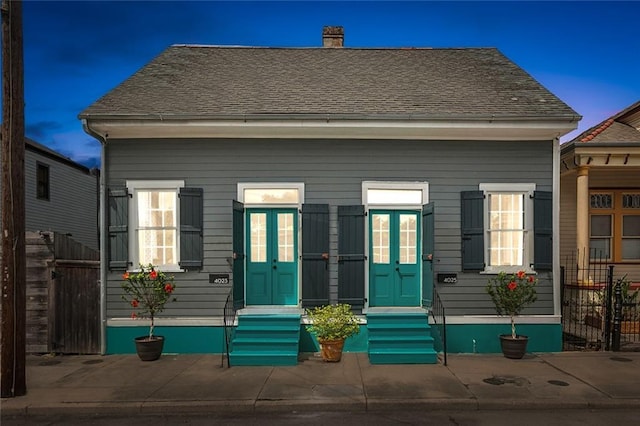 exterior space with fence, a chimney, and entry steps