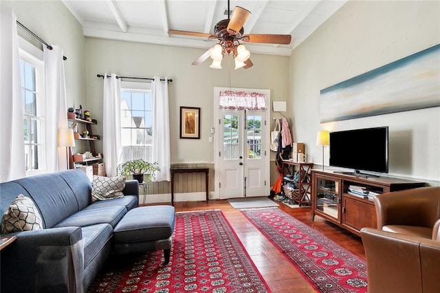 living room with wood-type flooring, ceiling fan, and beamed ceiling