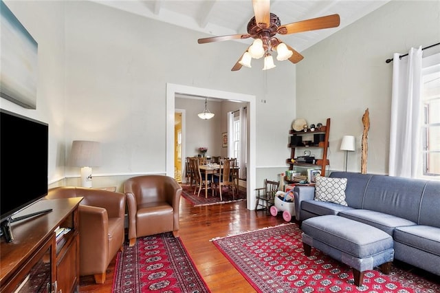 living area with high vaulted ceiling, ceiling fan, and wood finished floors