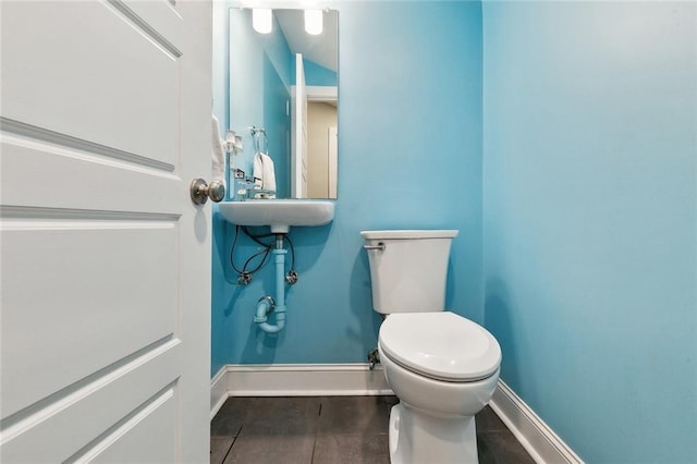 bathroom featuring baseboards, toilet, and wood finished floors