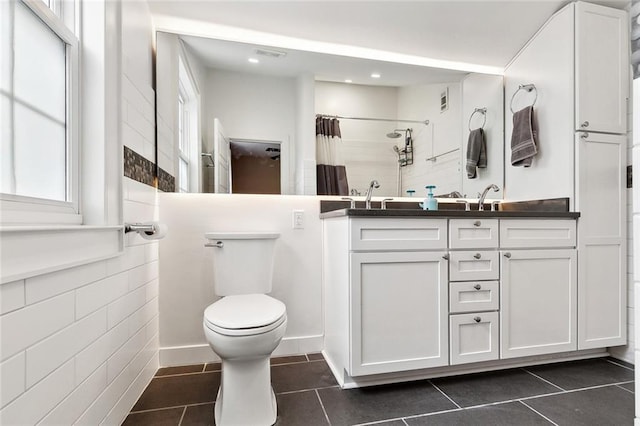 full bath with tile patterned flooring, curtained shower, vanity, toilet, and a wealth of natural light