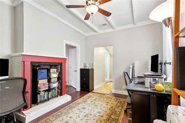 office space featuring a ceiling fan, visible vents, wood finished floors, baseboards, and beamed ceiling