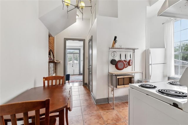 kitchen featuring white appliances, light tile patterned floors, a notable chandelier, and a wealth of natural light