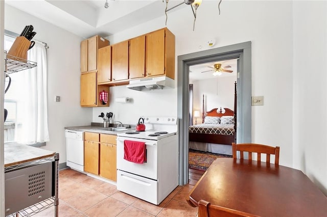 kitchen featuring under cabinet range hood, light tile patterned floors, white appliances, and light countertops