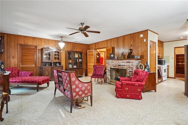2363 Lark St, New Orleans, LA 70122 - living area featuring wood walls, ceiling fan, dark aggregate flooring, and a fireplace