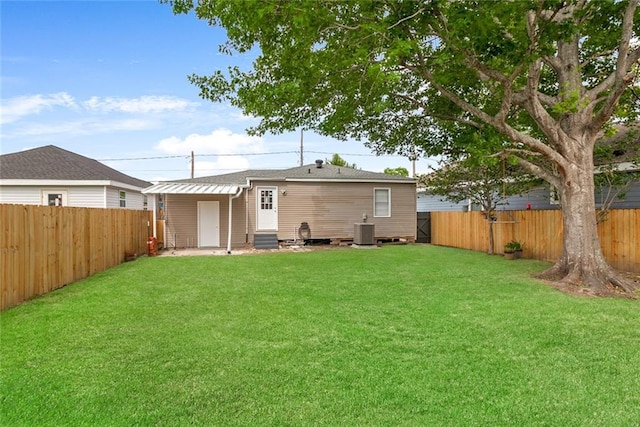 back of house with entry steps, central AC unit, a lawn, and a fenced backyard