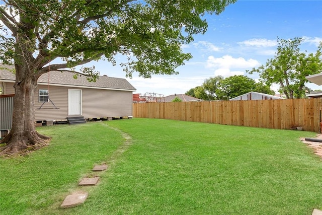 view of yard featuring a fenced backyard and entry steps