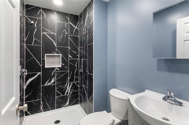 full bathroom featuring vanity, a stall shower, and toilet