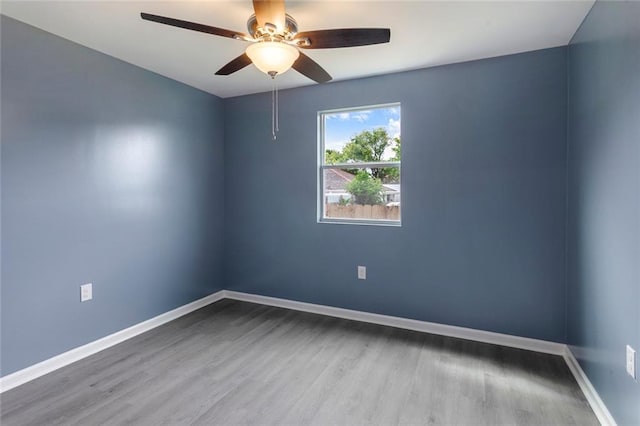 spare room featuring baseboards, ceiling fan, and wood finished floors