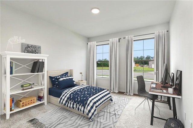 carpeted bedroom with an office area and baseboards
