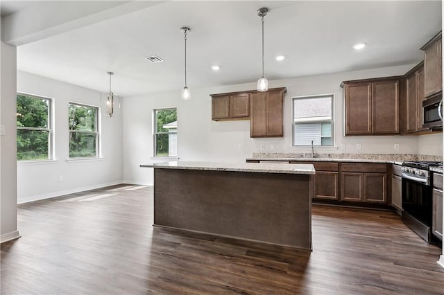 kitchen featuring appliances with stainless steel finishes, plenty of natural light, visible vents, and dark wood-type flooring