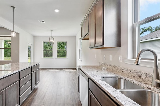 kitchen featuring a sink, visible vents, pendant lighting, dark wood-style flooring, and stainless steel dishwasher
