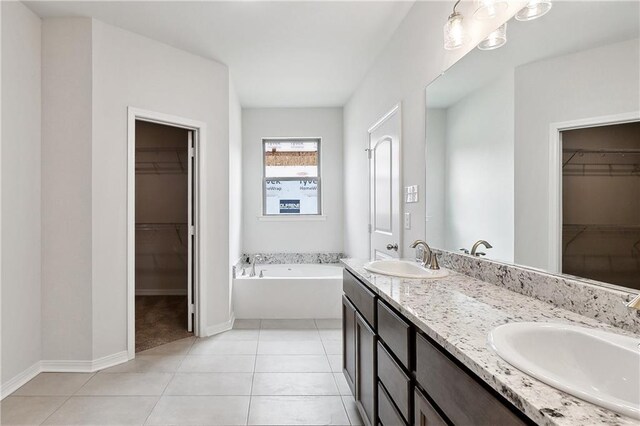 full bath featuring double vanity, a garden tub, tile patterned flooring, and a sink