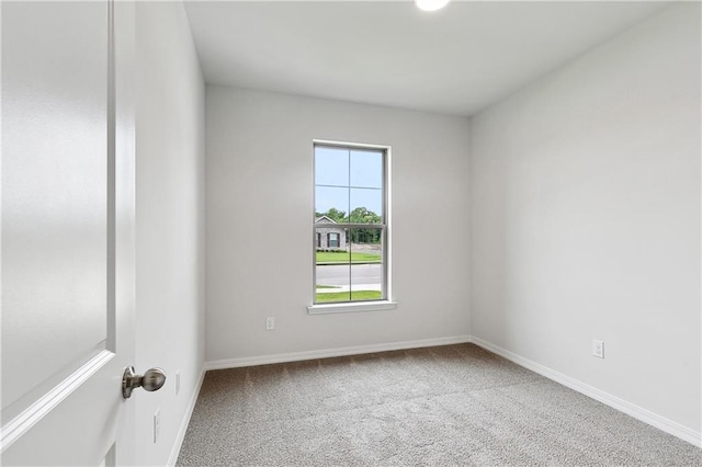spare room with baseboards and carpet flooring