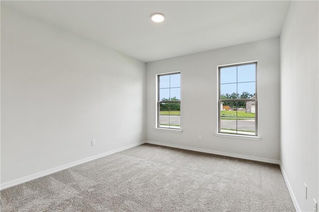 carpeted spare room with baseboards