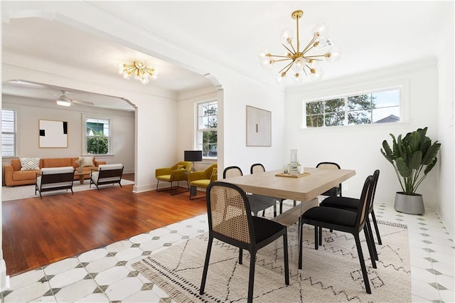 316 Claiborne Ct, Jefferson, LA 70121 - dining space with arched walkways, a chandelier, a healthy amount of sunlight, and wood finished floors
