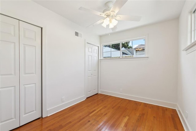 316 Claiborne Ct, Jefferson, LA 70121 - unfurnished bedroom featuring two closets, baseboards, visible vents, and wood finished floors
