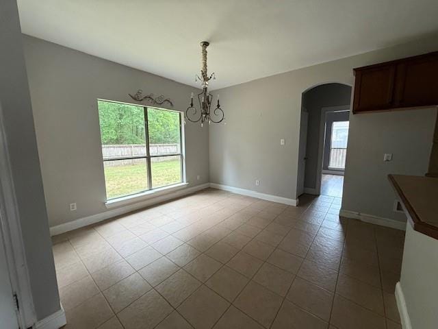 12742 Diamond Lake Dr, Walker, LA 70785 - unfurnished dining area with arched walkways, tile patterned flooring, a chandelier, and baseboards