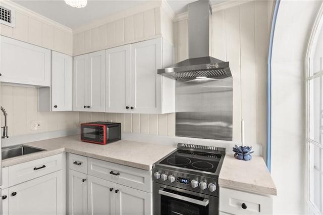 415 Burgundy St Unit 1B, New Orleans, LA 70112 - kitchen with stainless steel electric stove, wall chimney range hood, black microwave, a sink, and white cabinetry
