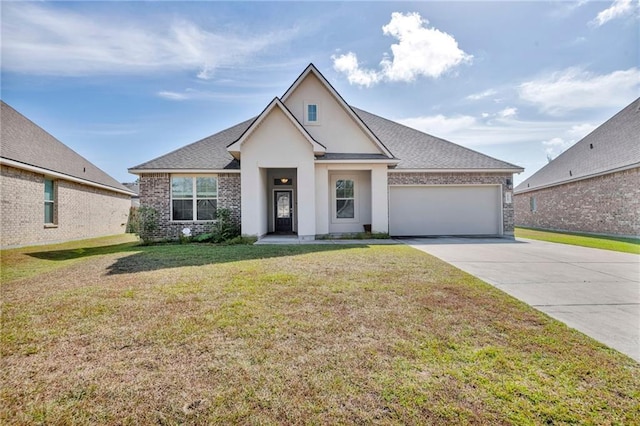 view of front of property with driveway, an attached garage, a front yard, brick siding, and stucco siding