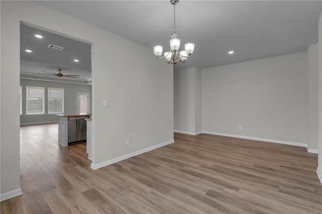 spare room featuring wood finished floors, recessed lighting, baseboards, a chandelier, and a ceiling fan