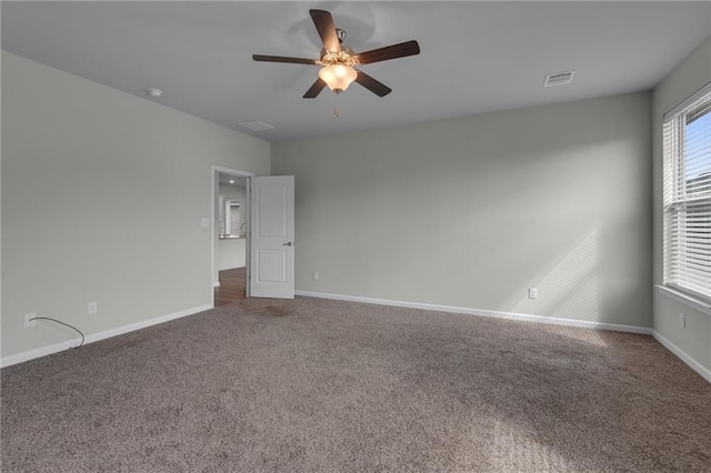 unfurnished room with carpet floors, a ceiling fan, and baseboards