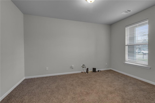 carpeted spare room featuring plenty of natural light and baseboards