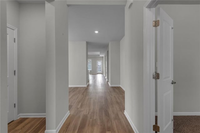 hallway with wood finished floors, baseboards, and recessed lighting