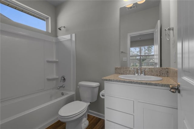 full bath with toilet, wood finished floors, vanity, bathtub / shower combination, and baseboards