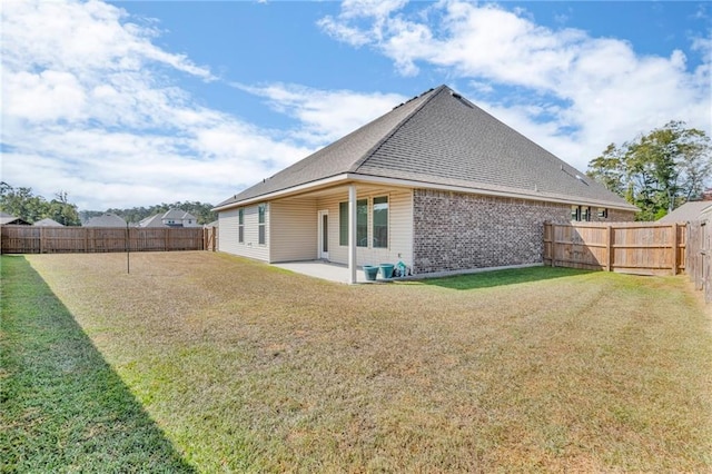 rear view of house featuring a patio area, brick siding, and a shingled roof