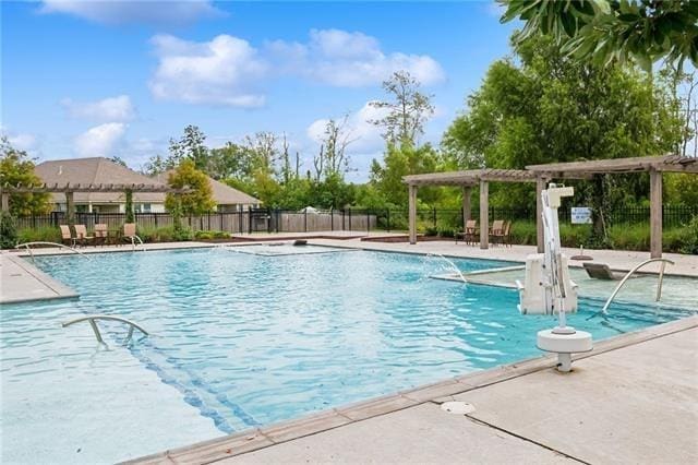 community pool with a pergola, fence, and a patio