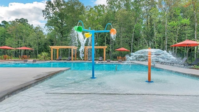 community pool featuring a water play area and a patio area